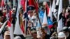 FILE - White nationalist demonstrators walk into the entrance of Lee Park surrounded by counter demonstrators in Charlottesville, Va., Aug. 12, 2017. 