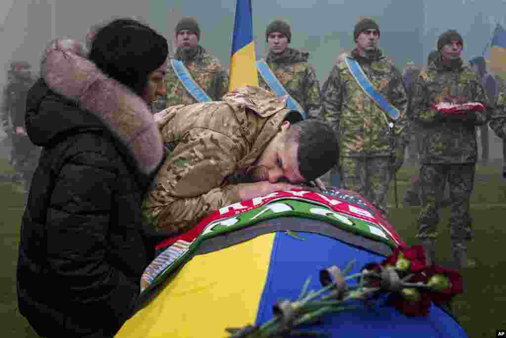 A Ukrainian serviceman bids farewell to his comrade Pavlo Vedybida aka "Obolonchik" at the Obolon Stadium in Kyiv, Nov. 30, 2024.