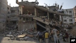 Warga Palestina memeriksa rumah mereka yang terkena serangan udara Israel di Kota Gaza, Senin, 8 Agustus 2022. (Foto: AP)