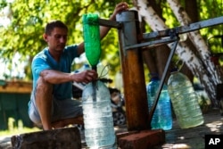 A resident fills up water bottles at a well in Sloviansk, Donetsk region, eastern Ukraine, Aug. 6, 2022.