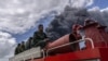 Los bomberos se desplazan en un camión dentro de la base de superpetroleros de Matanzas para sofocar un incendio que comenzó durante una tormenta eléctrica, en Matanzas, Cuba, el domingo 7 de agosto de 2022.