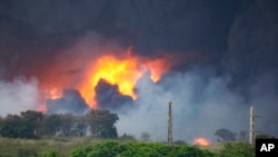 Flames and smoke rise from the Matanzas Supertanker Base as firefighters work to quell the blaze, which began during a thunderstorm, in Matanzas, Cuba, Aug. 8, 2022.