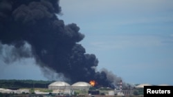 Se ve fuego sobre los tanques de almacenamiento de combustible que explotaron cerca del puerto de supertanqueros en Matanzas, Cuba, el 7 de agosto de 2022. REUTERS/Alexandre Meneghini