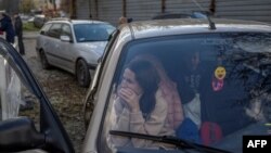 A Ukrainian woman sits in a car with her family in Zaporizhzhia, after they managed to escape from the Russian-occupied southern Ukrainian region of Kherson, Nov. 5, 2022.