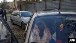 2022 年 11 月 5 日，一名乌克兰妇女和家人在逃离了俄罗斯占领的乌克兰南部赫尔松地区后，在扎波罗热坐在汽车里。