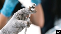 FILE - A pharmacist loads a syringe with monkeypox vaccine, Aug. 3, 2022, in West Hollywood, Calif. Spain is struggling to curtail Europe's leading monkeypox outbreak.