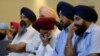 FILE - Members of the Sikh Temple of Wisconsin listen at a news conference in Oak Creek, Wisconsin, on Monday, Aug. 6, 2012, the day after a gunman walked into the temple and and opened fire, killing six and another who died later. 