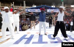 Kenya's opposition leader and presidential candidate Raila Odinga dances with Tanzanian musician Nasibu Abdul Juma Issack, during his final campaign rally ahead of the August 9 general election, at the Kasarani Stadium in Nairobi, Kenya, Aug. 6, 2022.