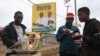Un vendeur de rue et ses clients devant un panneau d'affichage de campagne du vice-président et candidat à la présidence du Kenya, William Ruto, et de son colistier Rigathi Gachagua, à Nairobi, le 2 août 2022.