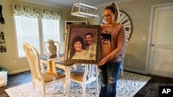 Angel Campbell of Hazard, Kentucky, holds up a photograph of her grandmother Nellie Mae Howard grandfather Earl Howard on Thursday, Aug. 4, 2022, in Chavies, Kentucky.