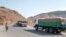 FILE - A man walks next to a convoy of trucks on their way to Tigray in the village of Erebti, Ethiopia, June 9, 2022.