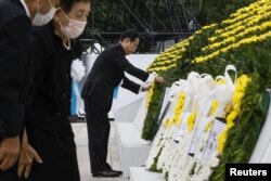 Japan's Prime Minister Fumio Kishida offers a wreath to the cenotaph for the victims of the 1945 atomic bombing, during a ceremony to mark the 77th anniversary of the world's first atomic bombing, at Peace Memorial Park in Hiroshima, western Japan, Aug. 6, 2022.