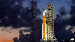 Roket NASA Artemis I dengan pesawat ruang angkasa Orion terlihat di pad 39B tepat setelah matahari terbenam di Kennedy Space Center, di Cape Canaveral, Florida, 27 Juni 2022. (Foto: AP)