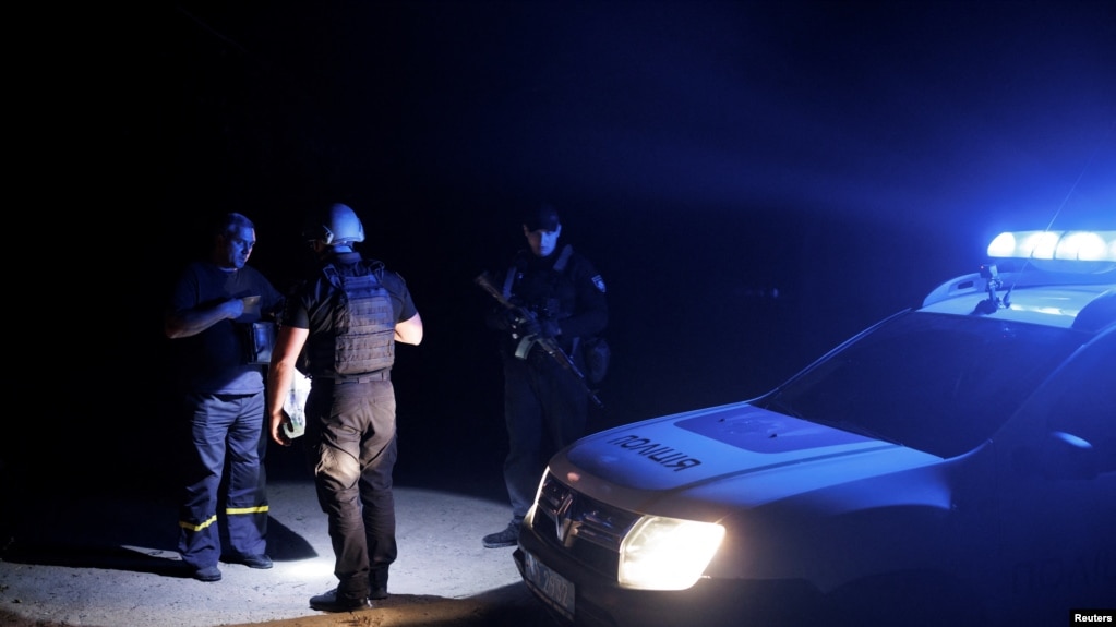 乌克兰城市克拉马托尔斯克市的警察宵禁开始后在夜间巡逻时检查一名行人的证件（2022年8月5日）(photo:VOA)