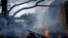 A local resident tries to stop the fire at a neighbor's house destroyed by a Russian attack in Mykolaiv, Ukraine, Aug. 5, 2022. 