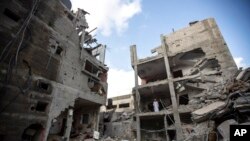 Palestinians search through the rubble of a building in which Khaled Mansour, a top Islamic Jihad militant, was killed following an Israeli airstrike in Rafah, southern Gaza strip, Aug. 7, 2022. 