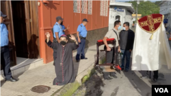 Monseñor Rolando José Álvarez reza frente a agentes policiales, quienes se han mantenido alrededor de la casa cural donde permanece. [Foto: Cortesía]
