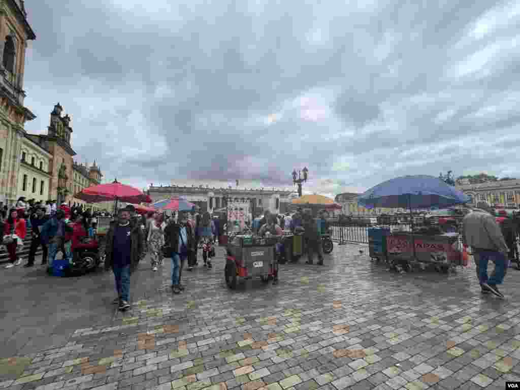 Turistas y locales caminan en la Plaza de Bolívar mientras se adelantan los trabajos para montar el escenario de los eventos protocolarios de la posesión de Gustavo Petro.
