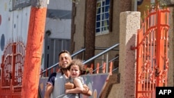 A Palestinian man carries his daughter after evacuating his home during an Israeli air strike in Gaza City, Aug. 7, 2022.