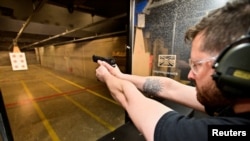 FILE - Andrew Trafananko, general manager of the Range Langley, fires a handgun in Langley, British Columbia, Canada, May 31, 2022. 