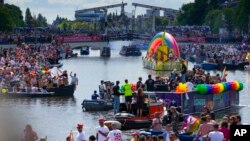 Hundreds of thousands of people lined canals in the Dutch capital to watch the Canal Parade, in Amsterdam, Netherlands, Aug. 6, 2022. 