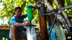 A resident fills up water bottles at a well in Sloviansk, Donetsk region, eastern Ukraine, Aug. 6, 2022.