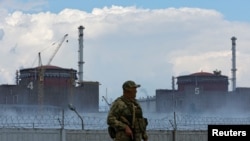 FILE - A serviceman with a Russian flag on his uniform stands guard near the Zaporizhzhia nuclear power plant outside the Russian-controlled city of Enerhodar in the Zaporizhzhia region, Ukraine, Aug. 4, 2022. 