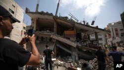 Palestinians inspect the damaged residential building after it was hit by Israeli airstrikes, in Gaza, Aug. 6, 2022.