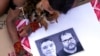 FILE - An Indigenous girl colors a poster with images of slain British journalist Dom Phillips, left, and Indigenous expert Bruno Pereira in Brasilia, Brazil, June 23, 2022. 