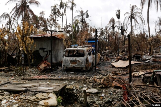 FILE - A car is seen near a house that was burnt down during the last days violence in Maungdaw, Myanmar Aug. 31, 2017.