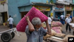 A porter carries a sacks of imported onions at a market place in Colombo, Sri Lanka, July 29, 2022.Sri Lanka