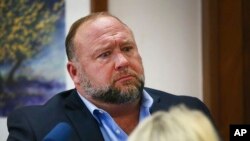 Conspiracy theorist Alex Jones answers questions about his emails asked by Mark Bankston, lawyer for Neil Heslin and Scarlett Lewis, during trial at the Travis County Courthouse in Austin, Aug. 3, 2022. 