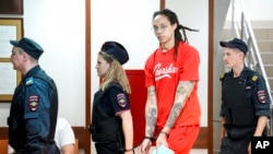 FILE - WNBA star and two-time Olympic gold medalist Brittney Griner is escorted to a courtroom for a hearing, in Khimki outside Moscow, July 7, 2022.