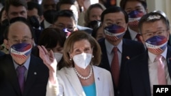 U.S. House Speaker Nancy Pelosi, center, waves to journalists during her arrival at Parliament in Taipei on August 3, 2022.