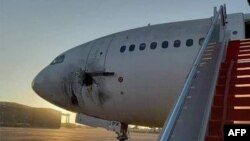 A handout photo released by the Iraqi ministry of transportation on its the Facebook page, shows a damaged aircraft on the tarmac of Baghdad airport, after rockets reportedly targeted the runway, Jan. 28, 2022. Four people were sentenced to life in prison over the attacks Sunday.