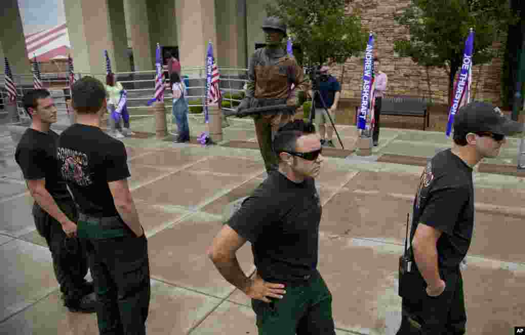 Members of the Ironwood Hotshots crew file past a new statue of a firefighter outside Tim's Toyota Center in Prescott, Arizona, July 8, 2013. 