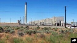 FILE--The Plutonium Uranium Extraction Plant (R) stands adjacent to a dirt-covered rail tunnel (L) containing radioactive waste, amidst desert plants on the Hanford Nuclear Reservation near Richland, Wash., June 13, 2017. 