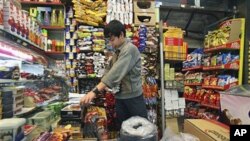 Iranian worker Jafar Rahimi works at his shop in central Tehran, Iran, after Iran's President Mahmoud Ahmadinejad announced the start of a plan to slash energy and food subsidies, part of government efforts to boost the nation's ailing economy, Dec. 18, 2