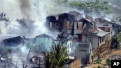 Asap nampak membumbung dari bangunan yang terbakar di Meikhtila, Burma tengah, di mana terjadi kerusuhan antara warga Buddha dan Muslim (foto, 21/3/2013).