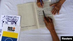 A supporter of Venezuela's President Nicolas Maduro signs a petition against the U.S. sanctions on Venezuela during a gathering in Caracas, Venezuela August 11, 2019. 
