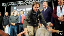 El candidato presidencial por la oposición, Luis Lacalle Pou, saluda a sus seguidores en evento de su campaña en San José, Uruguay, el 22 de octubre de 2019. AP.