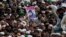 People hold the photo of police officer Mumtaz Qadri, the convicted killer of a former governor, during his funeral, in Rawalpindi, Pakistan, Tuesday, March 1, 2016. 