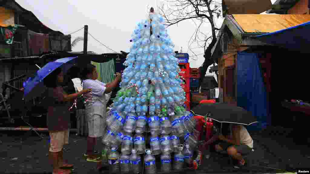 Vítimas do tufão Haiyan improvisam uma árvore de Natal com garrafas de água vazias. Cidade de Tacloban, Filipinas. Dez 24, 2013.