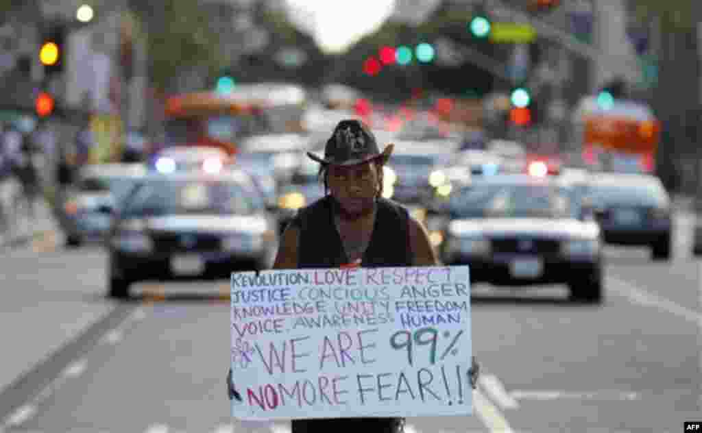 An Anti-Wall Street demonstrators marches in downtown Los Angeles, Monday, Oct. 3, 2011. The demonstrators entering their third day of a campout protest at Los Angeles City Hall said Monday they're planning to continue their action as long as it takes to