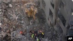 Equipas de salvamento procuram vítimas no local de um ataque aéreo israelita que atingiu o centro de Beirute, no Líbano, no sábado, 23 de novembro de 2024.