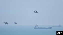 Chinese military helicopters fly past Pingtan Island on August 4, 2022, ahead of massive military drills off Taiwan. Pingtan Island is part of Fujian Province and one of China's closest points to Taiwan. (Hector Retamal/AFP