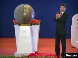 Chinese President Xi Jinping applauds after unveiling a sculpture during the opening ceremony of the Asian Infrastructure Investment Bank in Beijing, China, Jan. 16, 2016.