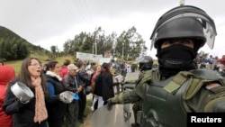 Demonstrators protest in front of riot policemen at the entrance of La Calera near Bogota, Aug. 28, 2013.