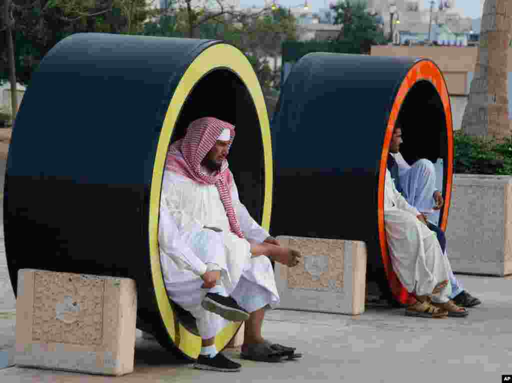 Saudis sit as they visit the Red Sea beach, in Jiddah, Saudi Arabia.