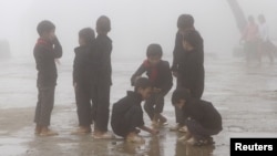 FILE - Children play during a class break on a foggy day, located on the China border on Sept. 21, 2015. Parents grew anxious after nearly 500 students from a middle school developed illnesses that are possibly linked contaminated soil and underground water adjacent to three former pesticide plants.